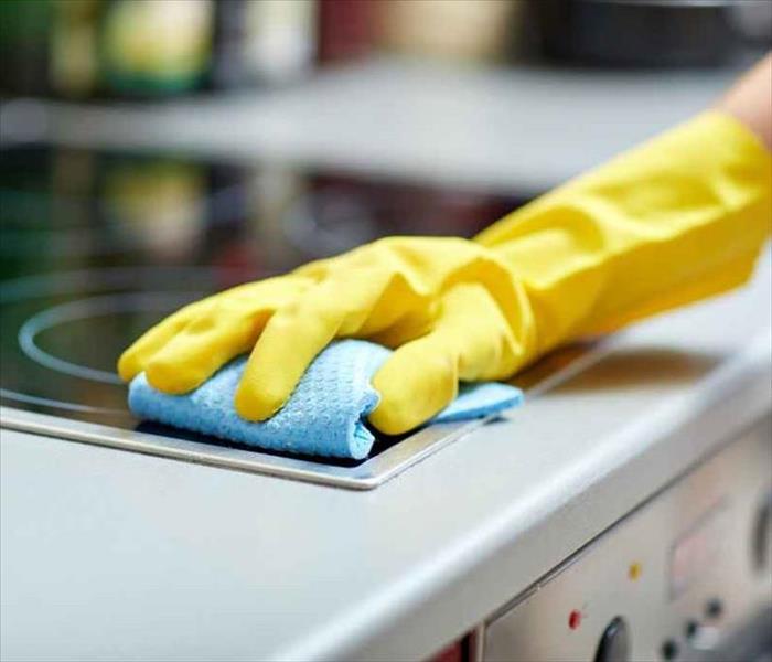 A person cleaning their stove