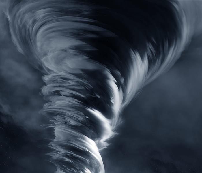 An illustration of a large tornado in front of mass of grey clouds